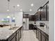 Modern kitchen with stainless steel appliances, granite countertops, and dark cabinets at 2432 Tangier Dr, Kissimmee, FL 34747
