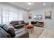 Bright living room features leather sofas, a modern TV stand, and neutral decor at 2432 Tangier Dr, Kissimmee, FL 34747