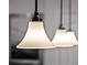 Close-up of three bronze pendant lights with white shades provide stylish illumination at 2432 Tangier Dr, Kissimmee, FL 34747