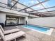 Backyard pool area featuring a screened-in pool with lounge chairs and patio at 2432 Tangier Dr, Kissimmee, FL 34747