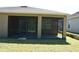 A covered back porch with screens has a view of the backyard and is situated next to a patio at 245 Brunswick Dr, Davenport, FL 33837