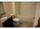 Bright bathroom features a granite countertop, tiled floor, toilet, and tub with white tiled walls at 245 Brunswick Dr, Davenport, FL 33837