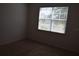 Bright bedroom featuring a window with blinds and a carpeted floor with neutral-colored walls at 245 Brunswick Dr, Davenport, FL 33837