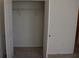 View into a closet with white shelving and doors and neutral-colored walls and carpeted floor at 245 Brunswick Dr, Davenport, FL 33837