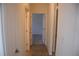 A hallway featuring tile floors leads to a bedroom with neutral carpeting at 245 Brunswick Dr, Davenport, FL 33837