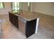 Kitchen island with dark cabinets, granite countertops, and stainless steel dishwasher at 245 Brunswick Dr, Davenport, FL 33837