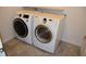 The laundry room features neutral tile flooring and modern washer and dryer units at 245 Brunswick Dr, Davenport, FL 33837