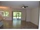 Open-concept living space with tile floors, ceiling fan, and sliding glass doors to the patio at 245 Brunswick Dr, Davenport, FL 33837