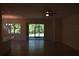 Open living room with neutral paint, ceramic tile flooring, and sliding glass door to backyard at 245 Brunswick Dr, Davenport, FL 33837