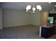 Open-concept living area featuring neutral walls and tile flooring, illuminated by a modern chandelier at 245 Brunswick Dr, Davenport, FL 33837