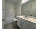 Bright bathroom features a shower over tub, white vanity, and a granite countertop at 2531 Blue Wave Pl, Oviedo, FL 32765