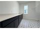 Laundry room showcases black cabinets, granite counters, decorative tile floor, and window at 2531 Blue Wave Pl, Oviedo, FL 32765