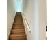 Staircase featuring wooden steps and a sleek white handrail at 2531 Blue Wave Pl, Oviedo, FL 32765
