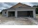 Unfinished stucco home with a three-car garage and architectural detailing under cloudy skies at 2644 Ravencliffe Ter, Oviedo, FL 32765
