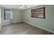 Cozy bedroom features wood-look vinyl floors, neutral paint, and two windows at 2836 S Stewart St, Kissimmee, FL 34746