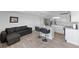 Modern living room with a gray sofa and a kitchen area with an island and stainless steel appliances at 2836 S Stewart St, Kissimmee, FL 34746