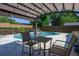 Inviting backyard pool with an outdoor dining area under a string-lit pergola at 3029 Peel Ave, Orlando, FL 32806