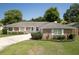 Charming single-story brick home featuring manicured landscaping and a concrete driveway at 3029 Peel Ave, Orlando, FL 32806
