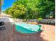 Backyard view of a sparkling private pool with a waterfall feature and brick-paved patio area at 310 Stakes Ct, Deland, FL 32724
