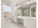 Bright bathroom features a double vanity, tiled floor, and a large window that fills the space with natural light at 3542 Shallot Dr # 108, Orlando, FL 32835
