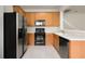 Functional kitchen featuring oak cabinets and modern black appliances at 3542 Shallot Dr # 108, Orlando, FL 32835