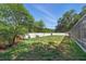 Lush backyard featuring grass, a white privacy wall and green trees at 392 Bayberry Dr, Polk City, FL 33868