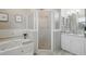 Bright bathroom with a garden tub, frosted glass shower, and white vanity with granite countertop at 392 Bayberry Dr, Polk City, FL 33868