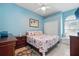 Bedroom features blue walls, floral bedding, an arched window, and a ceiling fan at 392 Bayberry Dr, Polk City, FL 33868