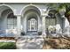 Covered front porch showcasing columns, arched entryway, and decorative glass front door at 392 Bayberry Dr, Polk City, FL 33868
