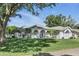Attractive one-story house featuring a manicured lawn, mature trees, and arched entryway at 392 Bayberry Dr, Polk City, FL 33868
