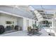 Enclosed patio area featuring a ceiling fan, sliding door, outdoor seating area, and a view of the beautiful pool at 392 Bayberry Dr, Polk City, FL 33868