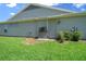 Exterior side view of home showcasing the backyard, side door, and central air system at 4687 Nw 35Th Lane Rd, Ocala, FL 34482