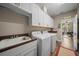 Well-equipped laundry room with washer, dryer, utility sink, and overhead cabinets at 4687 Nw 35Th Lane Rd, Ocala, FL 34482