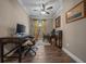This office features wood-look tile floors, a ceiling fan, and a window with beautiful yellow flower curtains at 4687 Nw 35Th Lane Rd, Ocala, FL 34482