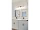 Modern bathroom featuring double sinks, white cabinetry, and a stylish lighting fixture at 492 Marion Oaks Mnr, Ocala, FL 34473
