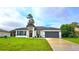 Charming single-story home featuring a gray roof, a gray garage door, and a beautifully landscaped front yard at 492 Marion Oaks Mnr, Ocala, FL 34473