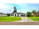 Charming single-story home featuring a gray roof, a gray garage door, and a beautifully landscaped front yard at 492 Marion Oaks Mnr, Ocala, FL 34473