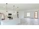 Open-concept kitchen featuring white cabinets, stainless steel appliances, an island, and light gray flooring at 492 Marion Oaks Mnr, Ocala, FL 34473