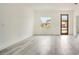 Spacious living room featuring light gray floors, white walls, a modern wood door, and a bright, open space at 492 Marion Oaks Mnr, Ocala, FL 34473
