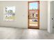 Bright living room showcasing a modern wood door, a big window, and sleek light gray flooring at 492 Marion Oaks Mnr, Ocala, FL 34473