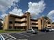 Beige two-story condo building with balconies and parking at 510 Cranes Way # 206, Altamonte Springs, FL 32701