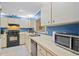Kitchen features a microwave, dishwasher, range, blue accent wall, and white cabinetry at 512 Derby Dr, Altamonte Springs, FL 32714