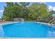 This community pool is surrounded by lush greenery with lounge chairs and a covered eating area at 512 Derby Dr, Altamonte Springs, FL 32714