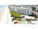Aerial view of beachfront condos, lush lawns, with a pool and the sandy shoreline at 5203 S Atlantic Ave # 416B, New Smyrna Beach, FL 32169