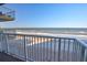 Balcony view overlooking the serene beach with white sands and gentle ocean waves at 5203 S Atlantic Ave # 416B, New Smyrna Beach, FL 32169