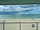 Balcony view overlooking a sandy beach with crashing waves and cloudy sky at 5203 S Atlantic Ave # 416B, New Smyrna Beach, FL 32169