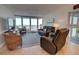Living room boasting comfortable seating, a television, and sliding glass doors to the balcony at 5203 S Atlantic Ave # 416B, New Smyrna Beach, FL 32169