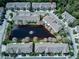 Aerial view of a residential area featuring well-maintained townhouses and a serene pond at 558 Pinebranch Cir, Winter Springs, FL 32708