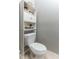 Cozy half bath with a toilet and a shelf for storing decor and personal items at 558 Pinebranch Cir, Winter Springs, FL 32708