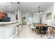Open-concept dining area with tile flooring, barstool seating, a wooden table, and a view of the front entry at 558 Pinebranch Cir, Winter Springs, FL 32708